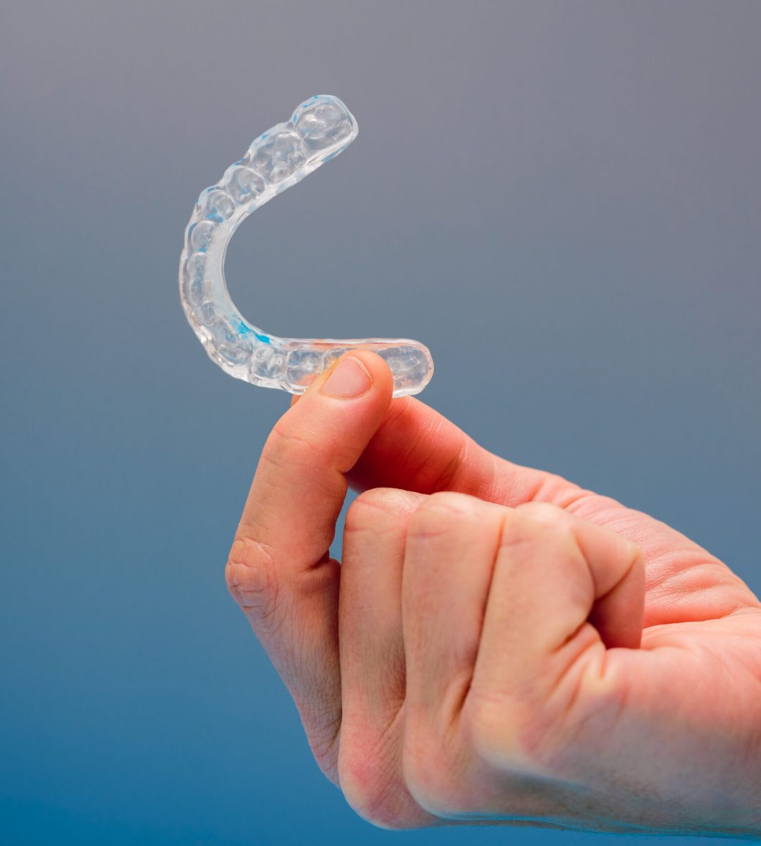 Dental aligner used by dental doctors isolated on blue background.